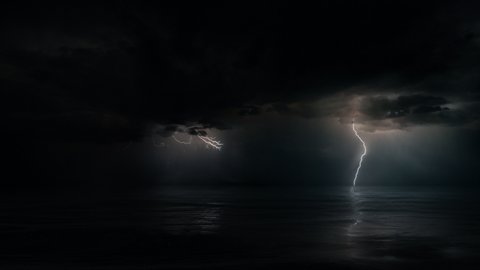 Dark mysterious monsoon cyclone storm clouds and multiple bolts of lightning. Tranquil eye of the storm above tropical Ocean at night. Looped conceptual establishing shot of powerful hurricane weather