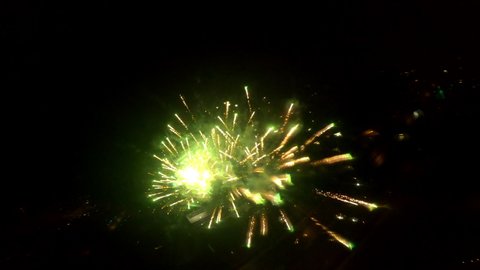 Drone FPV of red fireworks beautifully taking up the night sky, followed by colorful lights during New Year's Eve.