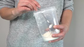Woman introducing flour from one pot into another with spoon
