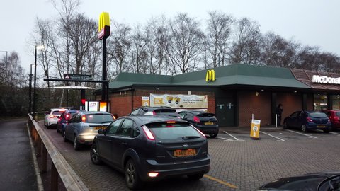 READING, UK - JANUARY 2, 2021: Cars move up the drive thru queue at a McDonald's restaurant in Reading, Berkshire, UK.