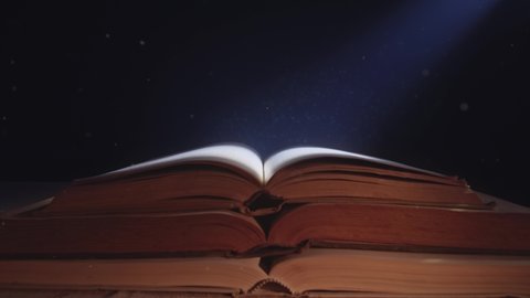 Dust particles flying in the moonlight over an opened old book.