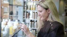 Female stylist or business owner in hairdressing salon checking beauty products using digital tablet - shot in slow motion - Powered by Shutterstock - Get 15% off with code: PIKWIZARD15