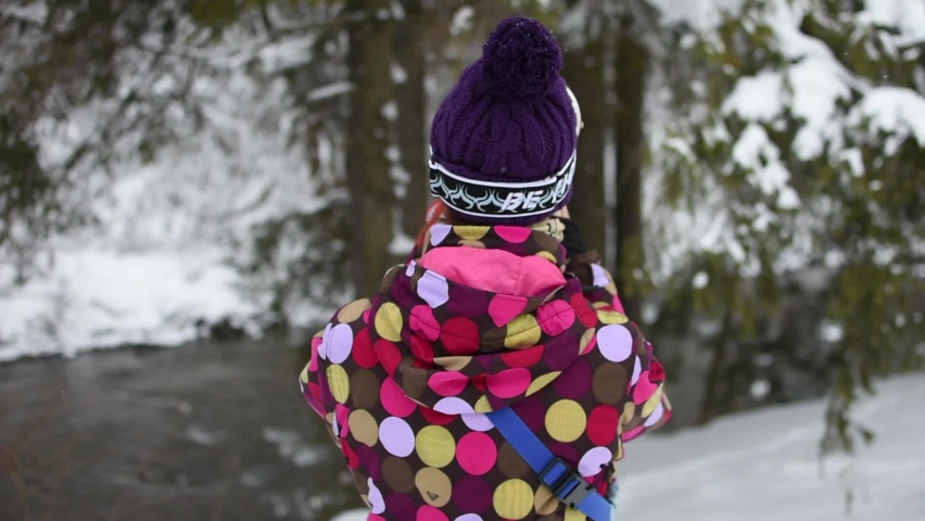 Young woman uses a smartphone to video a beautiful view in the forest at ski resort.