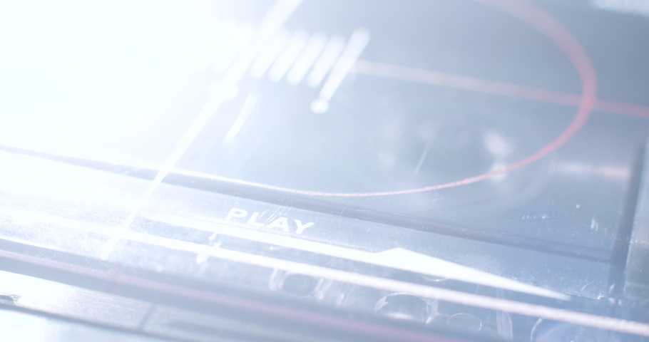 Tape Deck "PLAY", Ominous. A light dramatically sweeps across a macro close up of an old audio cassette player. | Shutterstock HD Video #1065547348