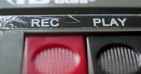 Press Record Button, Macro. A macro close up of the play-record buttons being pressed on an old audio cassette player.