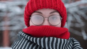 Portrait of a young woman in misted glasses outdoors on a frosty snowy day, camera zoom out - Powered by Shutterstock - Get 15% off with code: PIKWIZARD15