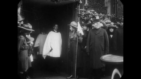 CIRCA 1913 - A bride and groom depart a church in a car, followed by their wedding party.