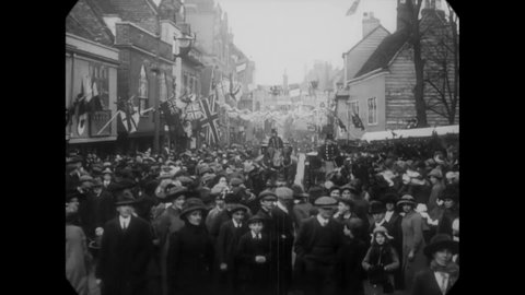 CIRCA 1913 - Crowds gather to see carriages of a wedding party drive by in Faversham, Kent, England.