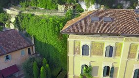 Panorama of Verona historical city centre, bridges across Adige river. Medieval buildings with red tiled roofs, Italy. Aerial video footage in 4K from above to Castel San Pietro and park.