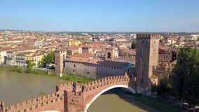 Verona, Italy: Aerial view of Castelvecchio Bridge (Ponte di Castelvecchio) and Castelvecchio Castle. Drone flies over the Adige river. Aerial video footage in 4K. 
