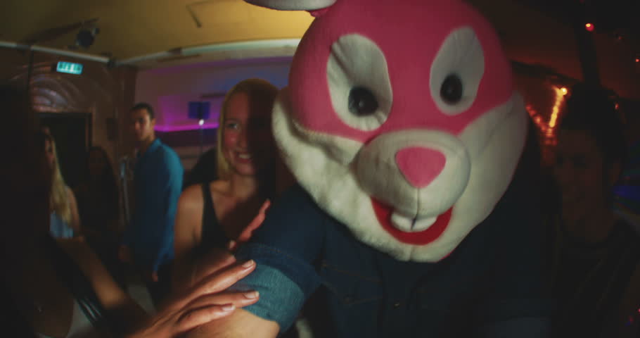 Group of friends at a party with one wearing a plush rabbit head Royalty-Free Stock Footage #10655663