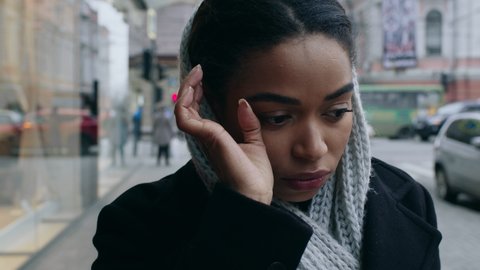 Coronacrisis and poverty. Close up portrait of young depressed black woman crying near shopping mall, no money for purchases, tracking shot