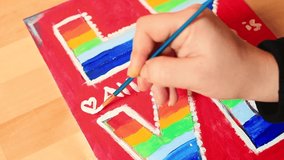 Talented artist's hand paints white heart symbol with brush as final touch to image written in multi-colored dyes. Make painting in art school. Close up european culture stance gay rights background - Powered by Shutterstock - Get 15% off with code: PIKWIZARD15
