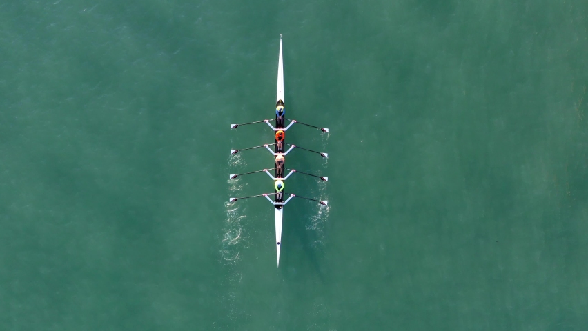 Sport Canoe with a team of four people rowing on tranquil water, Aerial view. Royalty-Free Stock Footage #1065578947