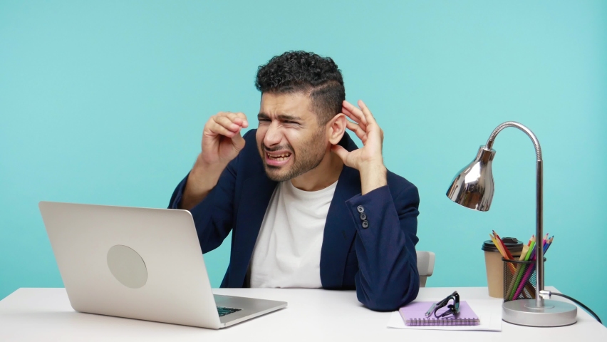 What? I cant hear you. Man in business suit trying to hear information, deafness, office work for people with disabilities. Indoor studio shot isolated on blue background | Shutterstock HD Video #1065580888
