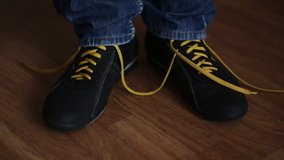 guy ties yellow laces on black crossbows