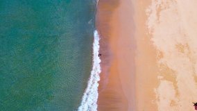 Aerial view of Video clip Top view Beautiful Beach and seawater surf on sandy. In sunny summer day. 4K UHD Nature and travel concept.
