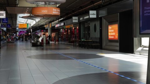 Schiphol, Amsterdam Netherlands - jan 15  2021:Time lapse over a time span of 8 minutes of human movement in a shopping corridor in entrance hall 3. video 4K 50fps. Quiet moment in the shops.
