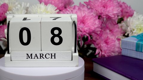 Desktop calendar with the date of March 8 and a bouquet of beautiful flowers. Delicate chrysanthemums for International Women's Day. Handmade wood cube with date month and day. planning for the day.