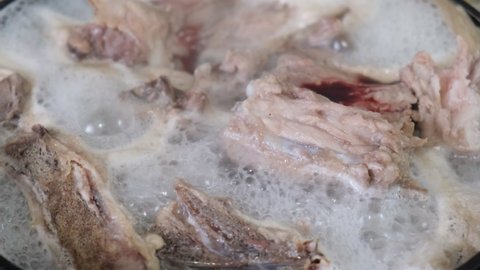 Pork bones boiling in meat broth, close up
