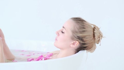 Beautiful Sexy Caucasian Blonde Girl In Bikini Lying In Flower Bath In Resort Day Spa Salon. Skin Care Therapy. Concept young woman relaxing in the bathtube. Slow motion video. stock footage