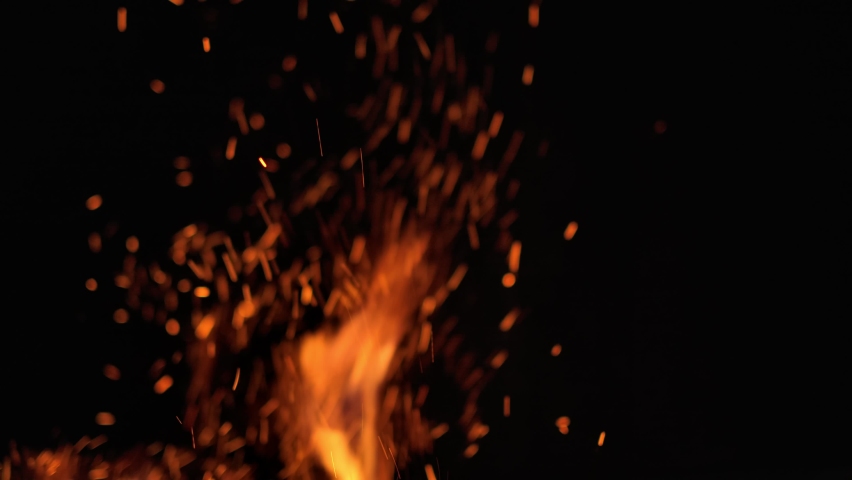 Fire Sparkles flying in the air. Particles of burning coal fire flames jump up and dancing with red flakes. Fire burning pattern Royalty-Free Stock Footage #1065608191