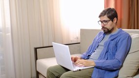 Relaxed serious millennial guy student or freelancer using laptop device