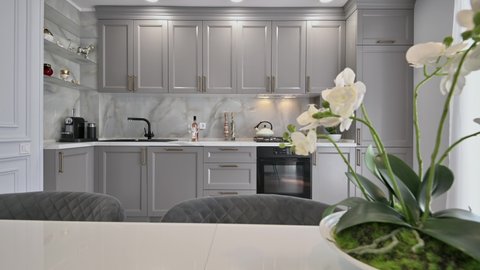 Grey and white contemporary classic kitchen interior with dining table designed in modern style, dolly camera movement