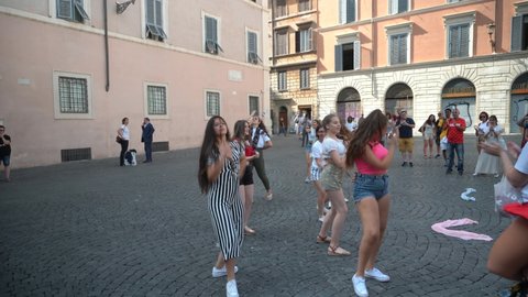 Rome, Italy - July 14, 2019: Group of girls perform a dance in the street on the square in front of the church of Santa Maria in Trastevere on a summer day