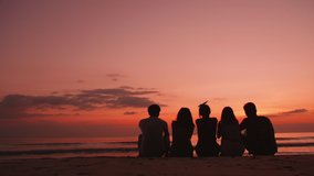 Back view silhouettes, group of young friends sitting and relaxing together on the beach at sunset. - Powered by Shutterstock - Get 15% off with code: PIKWIZARD15