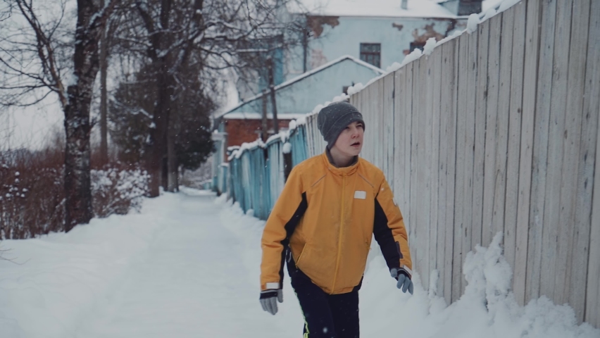 The guy shakes the snow off the edge of the fence. Wonderful slow-motion shots