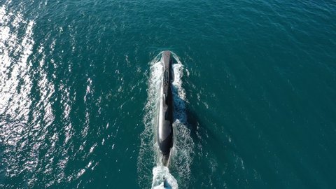 Aerial drone video of latest technology naval armed forces submarine cruising in deep blue open ocean sea