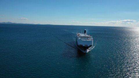 Aerial drone video of Large RoRo (Roll on-off) automobile - car transportation, carrier vessel cruising the Mediterranean deep blue sea