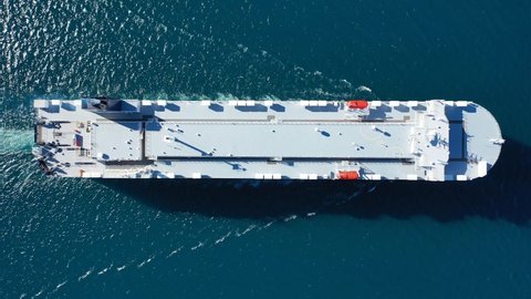 Aerial drone top down video of Large RoRo (Roll on-off) automobile - car transportation, carrier vessel cruising the Mediterranean deep blue sea