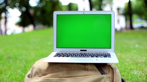 Green screen chromakey laptop blank screen in park outside. Mockup free content. Traveling freelance business lifestyle. Internet connecting. Online shopping. New education system. Nobody.