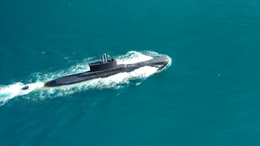 Aerial drone video of latest technology naval armed forces submarine cruising in deep blue open ocean sea