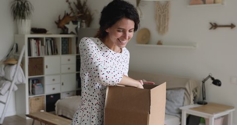 Emotional positive young woman feeling excited unboxing huge parcel with order from internet store, getting free gifts or wished item, satisfied with fast delivery service, online shopping concept.