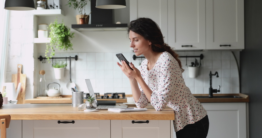Addicted to social networks young happy beautiful woman scrolling profile pages, zooming photos, reading friends life news feed posts using mobile phone application, standing in modern kitchen alone. Royalty-Free Stock Footage #1065667522