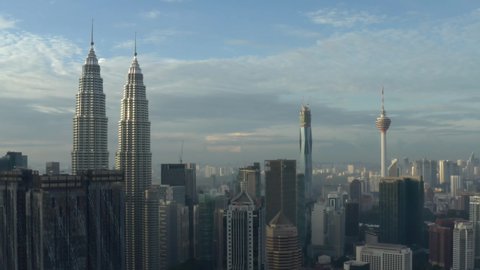 Kuala Lumpur, Malaysia - December 25, 2020: Establishing aerial cinematic drone b-roll shot of sunrise at Kuala Lumpur city skyline. Fly down
