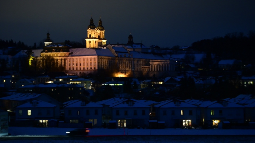 cars passing by the monastery of st.florian in upper austria on a winter evening
