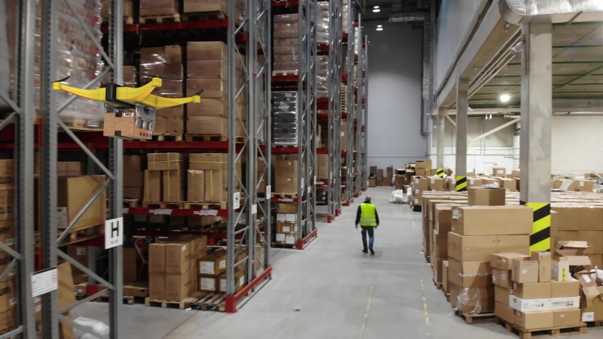 AERIAL. Group of delivery drones flights inside huge warehouse. Drone deliveries a goods. Futuristic concept. | Shutterstock HD Video #1065685405