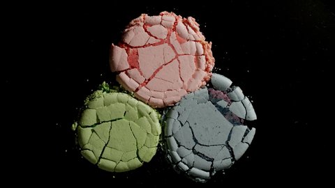 Crushing three Colorful Macarons On A Black Background