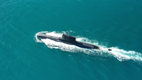 Aerial drone video of latest technology navy armed diesel powered submarine cruising half submerged in deep blue sea