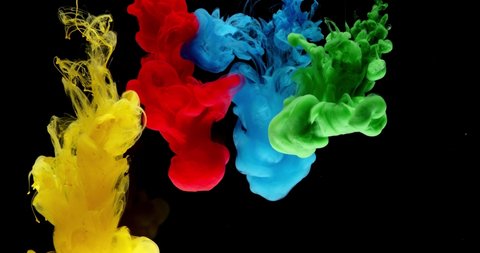 blue, yellow, green and red ink clouds in water in front of black backround in slowmotion