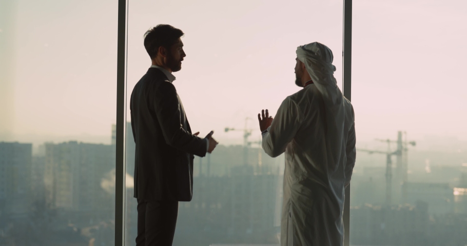 Multi-national two businessmen talking about investment agreement shaking hands collaborating in modern office cabinet. Arabian sheikh. | Shutterstock HD Video #1065718189