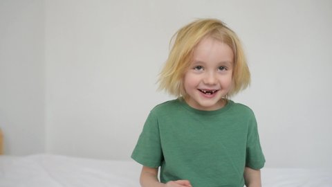 Laughing boy right after lost his wobbly milk tooth during it changes to the molar. Stages of growing up a child. Health care and dental hygiene for baby. Childhood