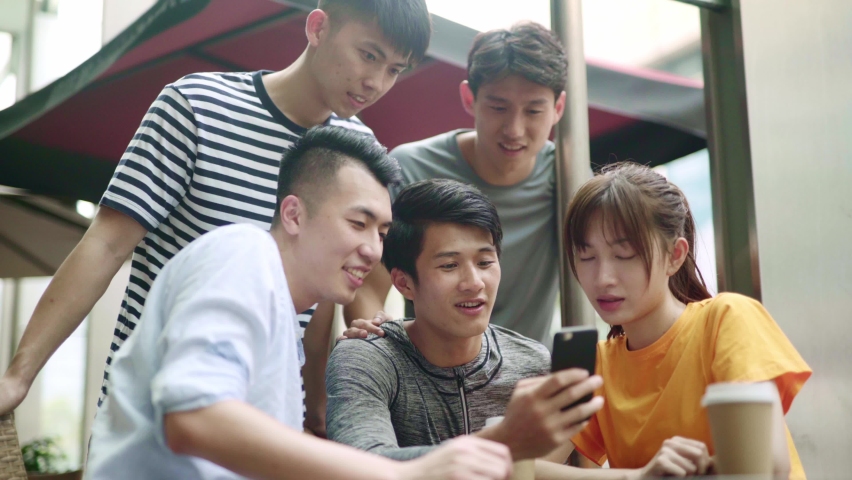 group of young asian adults looking at cellphone together happy and smiling Royalty-Free Stock Footage #1065732268