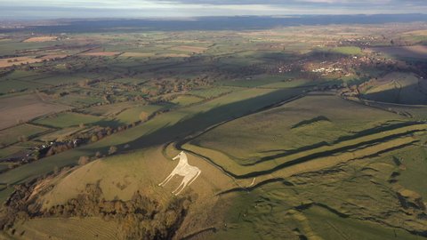 Aerial view of the famous White Horse below Bratton Camp, an Iron Age hillfort near Westbury, Wiltshire, England