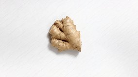 Ginger root on a white wooden background. Turntable. The view from the top.