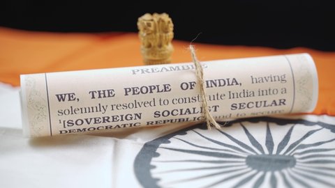 Pan view of Indian constitution or Bharatiya Savidhana preamble with we the people of India writings paper placed on Indian flag - Concept of Freedom, Nationality and patriotism